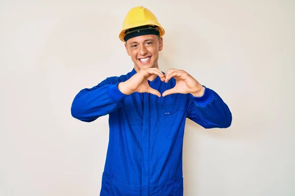 Młody Latynoski Chłopiec Mundurze Robotniczym Twardym Kapeluszu Uśmiechnięty Miłością Symbolami — Zdjęcie stockowe