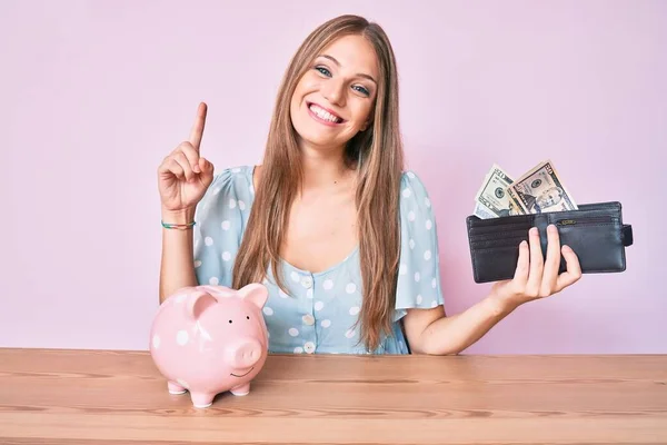 Jong Blond Meisje Houden Portemonnee Met Dollars Piggy Bank Zitten — Stockfoto