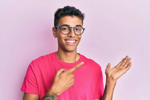 Joven Hombre Afroamericano Guapo Con Gafas Sobre Fondo Rosa Asombrado — Foto de Stock