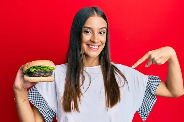 Fiatal Spanyol Hamburgert Eszik Ujjal Mutogatva Egy Boldog Büszke Önmagára — Stock Fotó