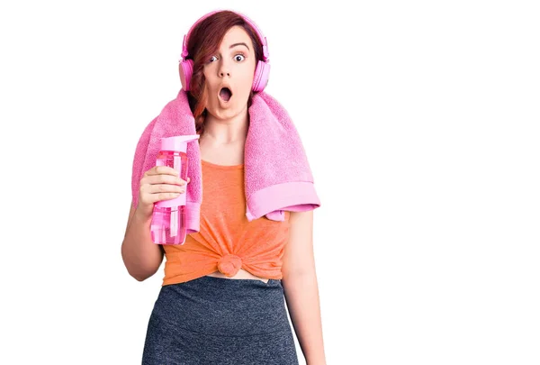 Young Beautiful Woman Wearing Sportswear Headphones Holding Bottle Water Scared — Stock Photo, Image