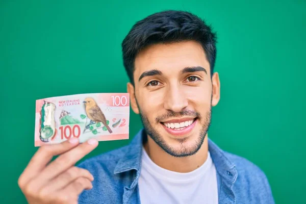 Joven Latino Sonriendo Feliz Sosteniendo Nuevo Zealand Billete 100 Dólares — Foto de Stock