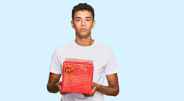 Junger Gutaussehender Afrikanisch Amerikanischer Mann Mit Geschenkdenken Und Nüchternem Gesichtsausdruck — Stockfoto