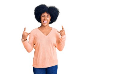 Sıradan kıyafetler giymiş, çılgın bir ifadeyle bağıran genç Afrikalı Amerikalı kız elleri havada rock sembolü yapıyor. Müzik yıldızı. ağır kavram. 