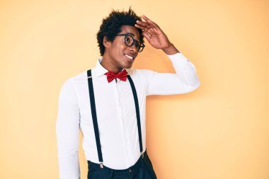 Afro saçlı, şık giyinen yakışıklı Afro-Amerikan erkeği. Çok mutlu görünüyor ve tebessüm ediyor. arama kavramı. 