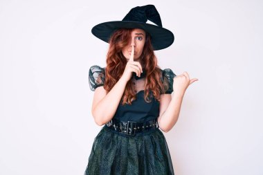 Cadılar bayramı kostümü giymiş genç ve güzel bir kadın sessiz olmak istiyor. Parmakları dudaklarında ve elleri yanda. sessizlik ve gizli konsept. 