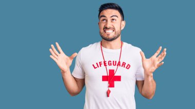 Cankurtaran üniforması giyen genç yakışıklı deli gibi bağırıyor ve agresif bir ifade ve kollarla bağırıyor. hüsran kavramı. 