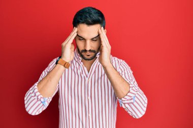 Genç İspanyol bir adam iş gömleği giyiyor. Baş ağrısı, çaresiz ve stresli. Ağrı ve migren yüzünden. Eller başının üstünde.. 