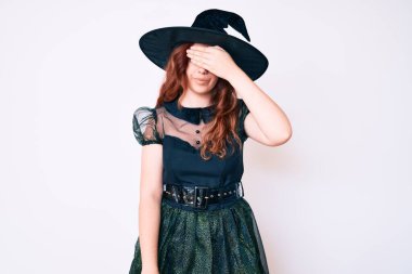 Cadı cadılar bayramı kostümü giyen genç ve güzel bir kadın. Gözlerine el sürmüş, ciddi ve üzgün görünüyor. Görme, saklama ve reddetme konsepti 