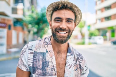 Genç İspanyol tatilde. Gülümsüyor. Şehrin caddesinde mutlu yürüyüşler.