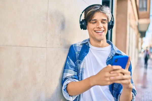 Joven Hombre Hispano Sonriendo Feliz Usando Teléfonos Inteligentes Auriculares Ciudad —  Fotos de Stock