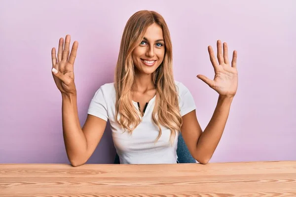 Vacker Blond Ung Kvinna Bär Casual Kläder Sitter Bordet Visar — Stockfoto