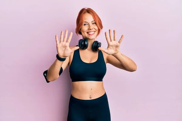 Ung Vacker Rödhårig Kvinna Gympakläder Och Med Hörlurar Som Visar — Stockfoto