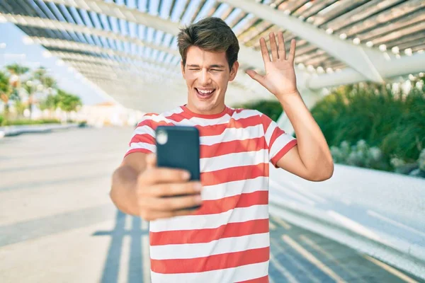 Jovem Caucasiano Sorrindo Feliz Fazendo Videochamada Usando Smartphone Cidade — Fotografia de Stock