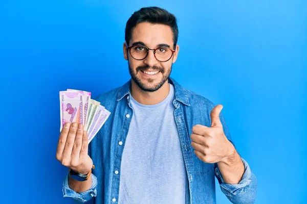 Joven Hombre Hispano Sosteniendo Billetes Rupias Indias Sonriendo Feliz Positivo — Foto de Stock