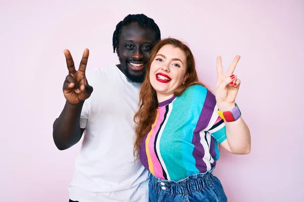 Interracial Couple Wearing Casual Clothes Smiling Looking Camera Showing Fingers — Stock Photo, Image