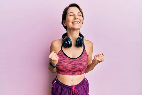Młoda Brunetka Krótkimi Włosami Ubrana Odzież Sportową Słuchawki Podekscytowana Sukcesem — Zdjęcie stockowe