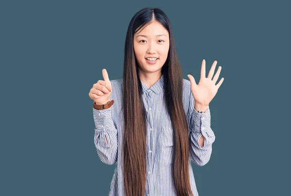 年轻美丽的中国女人 身穿休闲装 手指头指六号 面带微笑 自信而快乐 — 图库照片