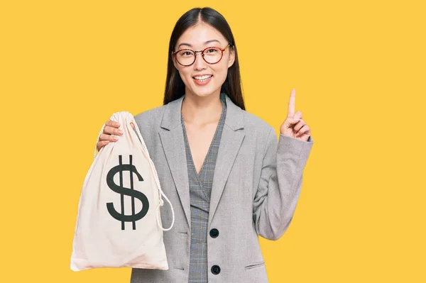 Jovem Chinesa Vestindo Terno Negócios Segurando Saco Dólares Surpreso Com — Fotografia de Stock