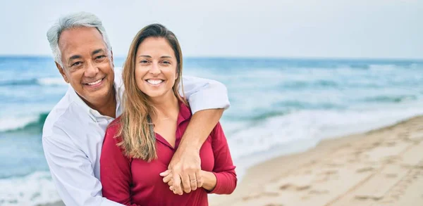 Pareja Hispana Mediana Edad Sonriendo Feliz Abrazándose Caminando Playa — Foto de Stock