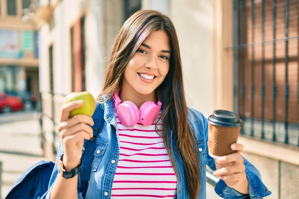 Young Hispanic Student Girl Smiling Happy Eating Apple Drinking Coffee — Stock Photo, Image