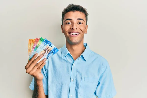 Νεαρός Όμορφος Αφροαμερικάνος Που Κρατάει Ελβετικά Χαρτονομίσματα Και Δείχνει Θετικός — Φωτογραφία Αρχείου