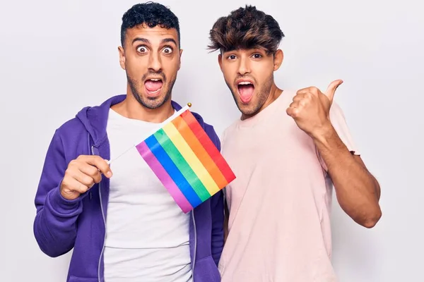 Joven Gay Pareja Celebración Arco Iris Lgbtq Bandera Apuntando Pulgar — Foto de Stock