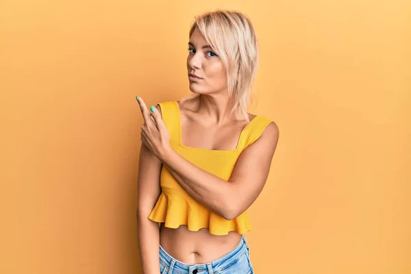 Młoda Blondynka Ubrana Luźne Ubrania Wskazujące Palcem Bok Pokazujące Reklamę — Zdjęcie stockowe