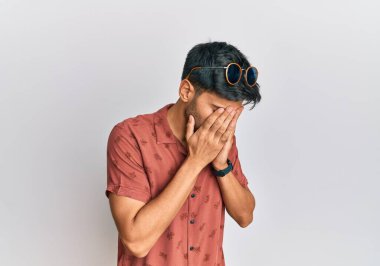 Yazlık kıyafetler giyen, suratını ellerle örten ve ağlayan genç yakışıklı bir adam. depresyon kavramı. 