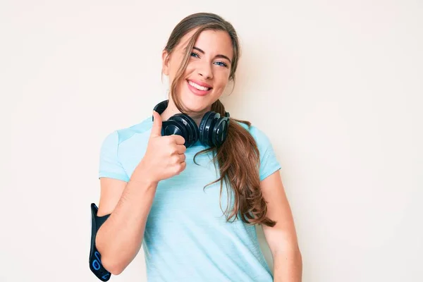 Krásná Mladá Běloška Tělocvičně Oblečení Pomocí Sluchátek Dělá Šťastné Palce — Stock fotografie