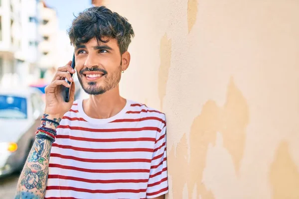 Joven Hombre Hispano Sonriendo Feliz Usando Teléfono Inteligente Apoyado Pared — Foto de Stock