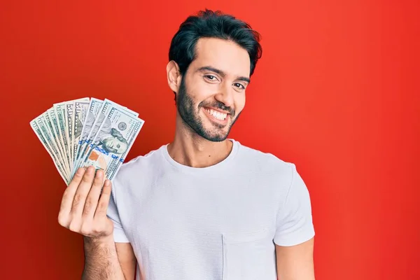 Young Hispanic Man Holding Dollars Looking Positive Happy Standing Smiling — Stock Photo, Image