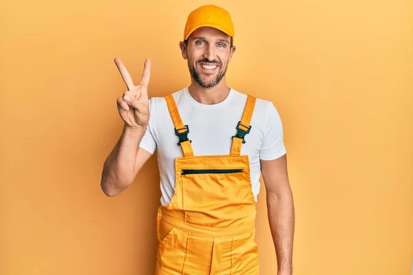 Joven Hombre Guapo Con Uniforme Manitas Sobre Fondo Amarillo Mostrando — Foto de Stock