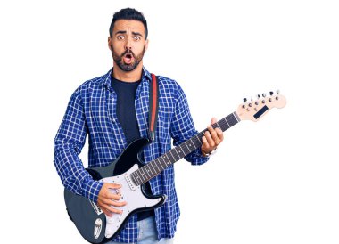 Genç İspanyol gitar çalan adam korkmuş ve ağzı açık bir şekilde şaşırmış, inançsız yüz. 