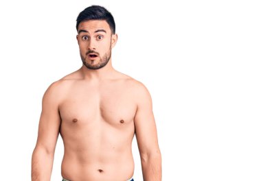 Şok yüzlü, mayo giyen genç yakışıklı, şüpheci ve alaycı görünüyor, ağzı açık kalınca şaşırıyor. 