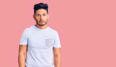 Yakışıklı, gündelik kıyafetler giyen, kuşkucu ve gergin, sorun yüzünden suratını asan Latin Amerikalı genç adam. negatif kişi. 