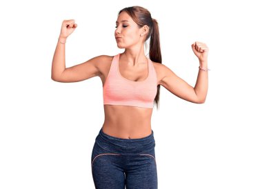 Genç ve güzel İspanyol kadın spor kıyafetleri giyiyor ve gururla gülümsüyor. fitness konsepti. 