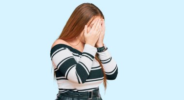 Genç, güzel, kızıl saçlı, zarif kıyafetler giyen, üzgün bir ifade takınan, ağlarken yüzünü elleriyle kapatan bir kadın. depresyon kavramı. 