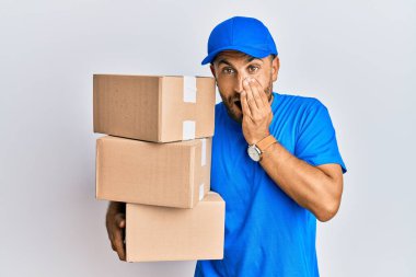 Sakallı yakışıklı adam kurye üniforması giyiyor teslimat paketleri taşıyor gülüyor ve utanıyor kıkırdıyor ağızları ellerle, dedikodularla ve skandallarla örtüyor 