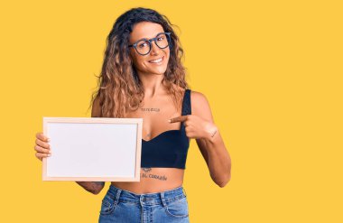 Dövmesi boş beyaz karatahta tutan genç İspanyol kadın mutlu ve gururlu bir kendini işaret ediyor. 