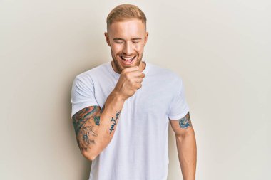 Beyaz gündelik tişört giyen genç beyaz bir adam kendini iyi hissetmiyor ve soğuk algınlığı veya bronşitin belirtisi olarak öksürüyor. sağlık hizmeti kavramı. 