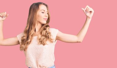 Sarışın, sıradan kıyafetler giyen, kollarında gururla gülümseyen beyaz bir kadın. fitness konsepti. 