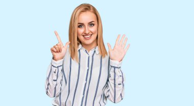 Kafkasyalı güzel bir kadın günlük kıyafetler giyer ve yedi numaralı parmaklarını göstererek gülümseyerek mutlu ve kendinden emin bir şekilde gösterir.. 