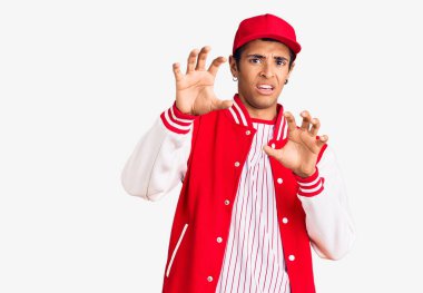 Beyzbol üniforması giyen, korku ifadesinden korkan genç Afrikalı Amerikalı adam el kol hareketi yapmayı kes, şok içinde bağır. panik konsepti. 