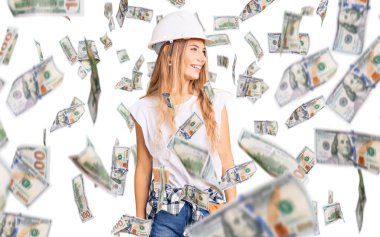 Güzel beyaz kadın, sarı saçlı, askılı şapka takan ve boyacı kıyafetleri giyen yüzünde gülümsemeyle, doğal bir ifadeyle yan yana bakan. Kendinden emin gülen.