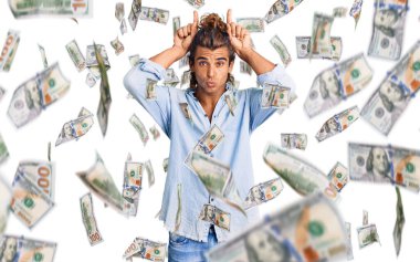 Yaz stili giyinmiş genç İspanyol bir adam komik jestler yapıyor parmakları kafasının üstünde boğa boynuzu gibi