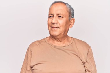 Gri saçlı, sıradan tişörtler giyen, rahat bir görünüm takınan, doğal yüzlü ve kendine güvenen bir gülümseme takınan son sınıf öğrencisi.. 