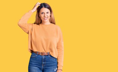 Gündelik giysiler giyen güzel genç bir kadın soru sorup kafasını karıştırıyor. Şüpheyle kararsız, kafa kafaya düşünerek. Düşünceli kavram. 