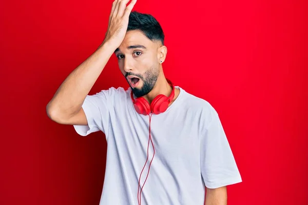 Joven Con Barba Escuchando Música Usando Auriculares Sorprendidos Con Mano — Foto de Stock