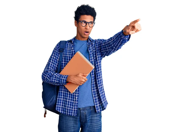 Joven Hombre Afroamericano Vistiendo Mochila Estudiante Sosteniendo Libro Apuntando Con —  Fotos de Stock